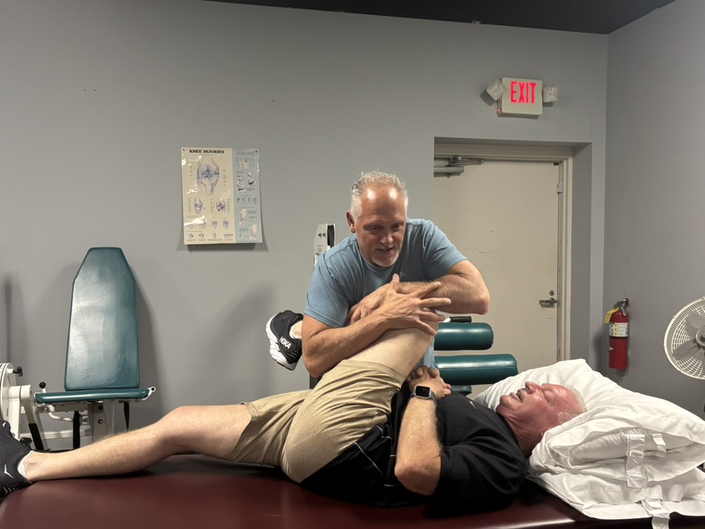 Bobby Canecchio providing hands-on manual stretching to a patient