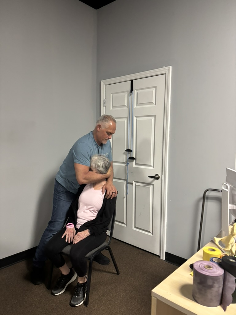 Bobby stretching a patient's leg during therapy